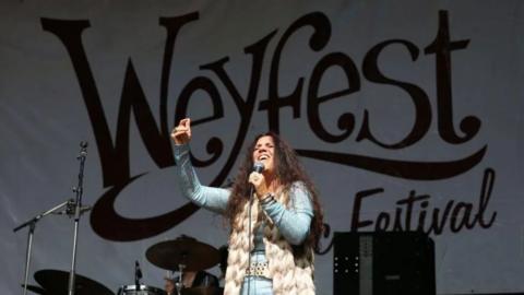 Sari Schorr performs on Day two of Weyfest Music Festival 2023 at the Rural Life Living Museum. A banner behind her on the stage reads Weyfest Festival.