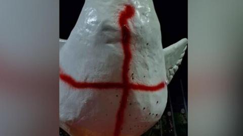 Goosey the Goose with two red lines sprayed across the statue which is white