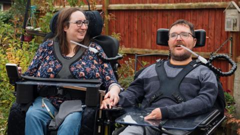 Charlotte and Tom Hardwick sitting in their wheelchairs in a garden