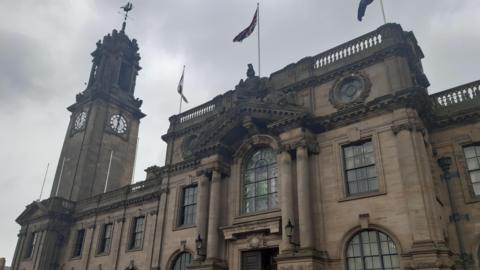 South Shields Town Hall, an elaborate and elegantly designed building with tall windows, carved pillars, and a sculpted depiction of a knight atop an arched roof.