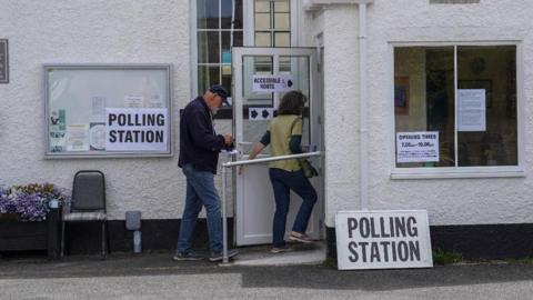 A man and a woman entering a polling station in Hastings