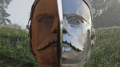 Sculpture showing a face in two halves, one side is shiny silver metal, the other is rust