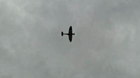 A Spitfire outlined against a cloudy sky