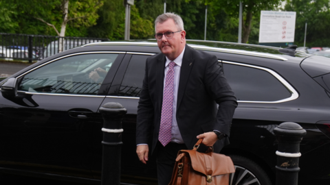 A man in a suit getting out of a car 