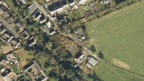 A 2007 satellite image of the site located in Innerleith near the Scottish Borders. The site is in the centre of the image with houses around it. There does not appear to be much on it.