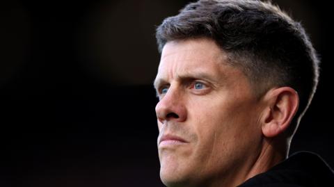 A close-up of Alex Revell in front of a black background