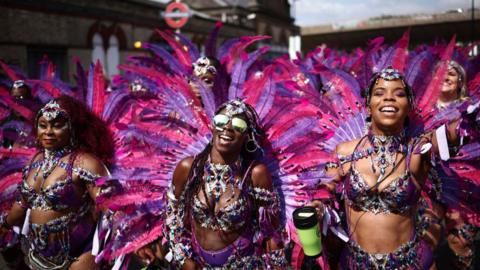 Performers in costume take part in the main parade of the Notting Hill Carnival in west London on 26 August 2024.
