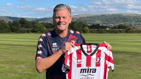 Steve Cotterill holding a Cheltenham shirt