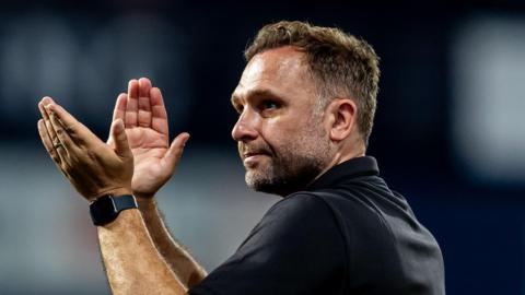 John Eustace applauding.