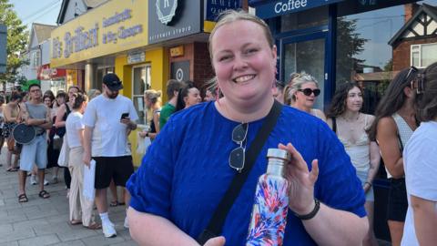 Chloe wearing a blue shirt and a painted metal bottle