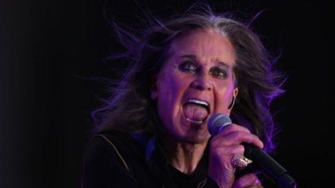 Ozzy Osbourne sings on stage.
