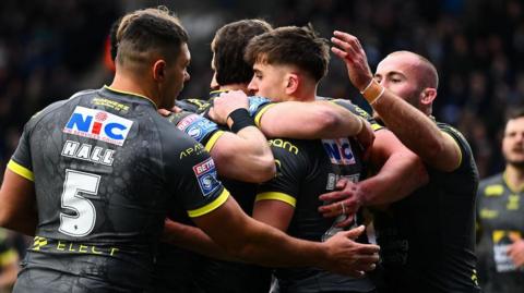 Leeds Rhinos player George Brown is congratulated by team-mates after scoring a try against Widnes Vikings.