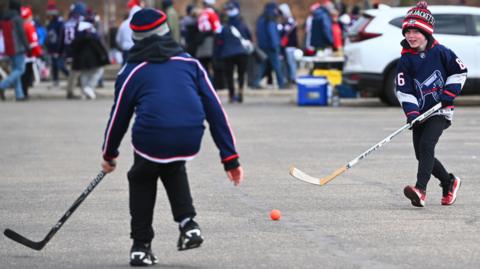 Fans play ball hockey in the parking lot before the NHL Stadium Series game between the Detroit Red Wings and the Columbus Blue Jackets at Ohio