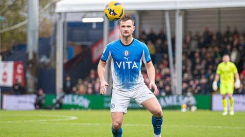 Callum Connolly prepares to head the ball for Stockport County.