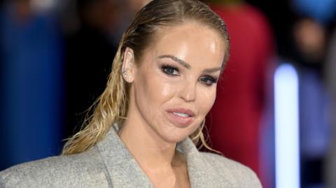 Katie Piper is dressed in a grey jacket and looks directly at the camera as she attends a public function on 15 November 15, 2022 in London