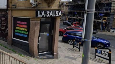 Street view of La Salsa lapdancing club on the corner of two streets. The street on the left of the image is 'Cow Green'. The sign in the window reads 'Lap Dancing, Poledancing, Wedding Parties, Birthdays & Events, Special Occasions'. 