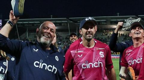 Darren Lehmann holds a trainer aloft during celebrations with his Northamptonshire Steelbacks players at the T20 Blast final
