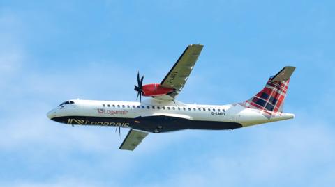 A Logan Air plane pictured in the air. A blue sky is visible in the background. 