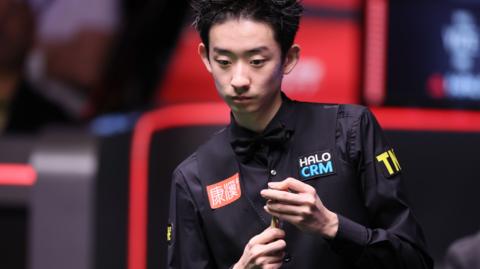 Wu Yize chalks his cue