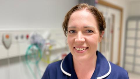 A nurse in blue uniform in a hospital room 