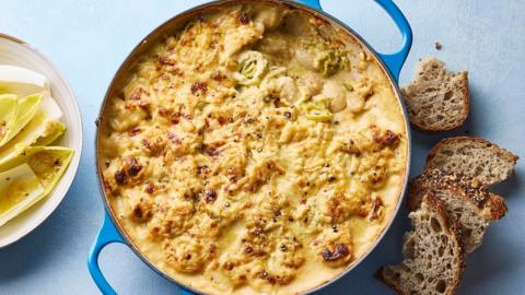 Cheddar, leek and butter bean bake with chicory salad, in a blue cast iron pan