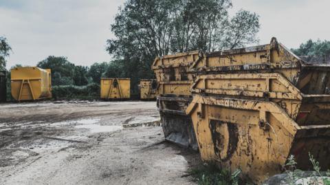 Yellow tips are seen piled up in a scrapyard