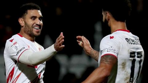 Jamie Reid of Stevenage (left) celebrates scoring his side's third goal against Bristol Rovers