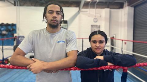 Marcel and Serena are standing next to each other in a boxing ring. 