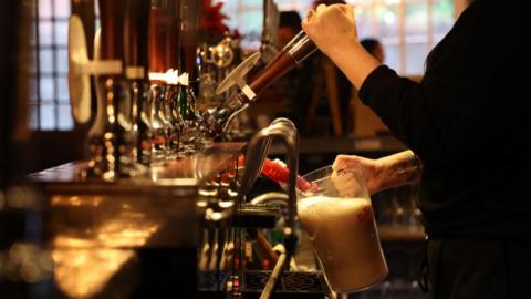 A member of staff changes the beer inside a pub