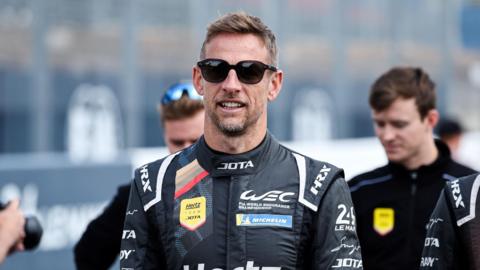 Jenson Button walking in the pitlane ahead of a race in 2024