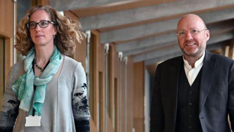 Lorna Slater and Patrick Harvie walking in the Scottish Parliament building 