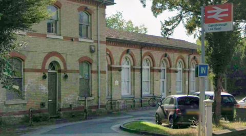 Gainsborough Lea Road railway station. The image shows a brick building with several large arched windows. A sign outside reads Gainsborough Lea Road with the railway logo.