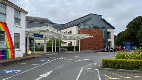 An entrance at Princess Elizabeth Hospital in Guernsey. One of the buildings has a rainbow painted on it.