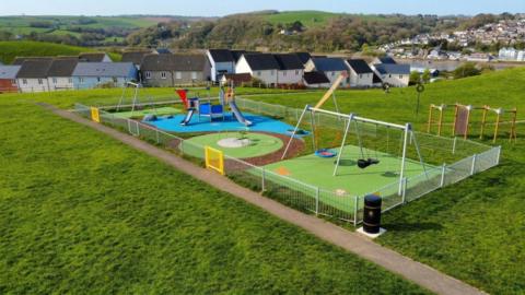 An ariel view of the East-the-water in Pollyfield play park. It has fresh equipement including two swings and a climbing frame with a slide.
