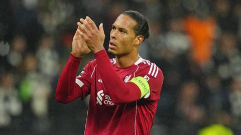 Virgil van Dijk applauds towards fans after a Champions League game