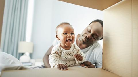 A dad with a young baby in a bedroom