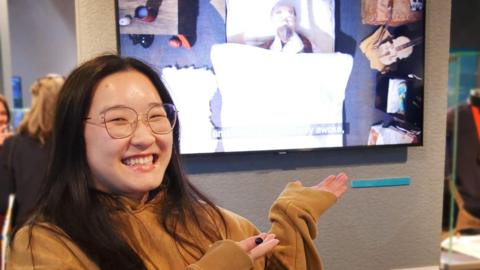 Lancashire smiling while pointing to a screen showing the animation.