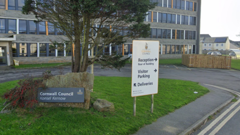 Cornwall Council building with a parking sign and a tree in front of it 