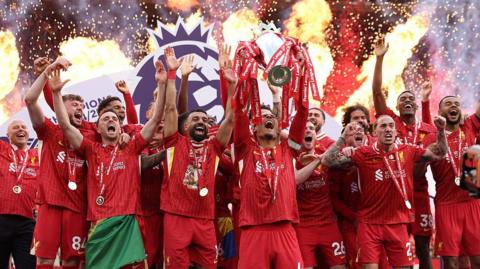 Virgil van Dijk and the Liverpool squad lifting the Premier League title at Anfield