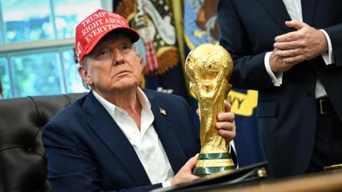Donald Trump holding the Fifa World Cup trophy in the Oval Office