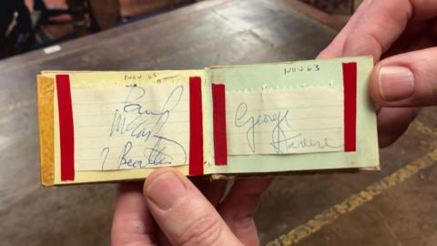 A small book with autographs including that of Paul McCartney and George Harrison. They are dated November 1963.