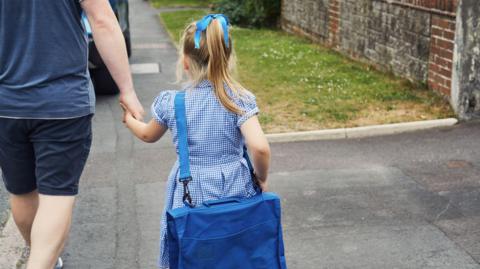 Father and daughter walking to school