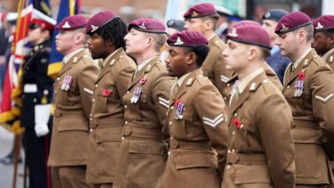 Soldiers wearing pink berets on parade wearing medals