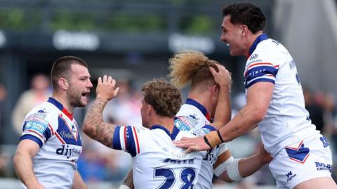 Wakefield Trinity player Max Jowitt (left) is congratulated on his try against Salford City Reds with teammates.