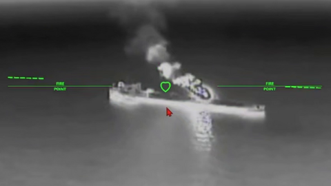A still image of an oil tanker under attack from a drone in a black and while nighttime image