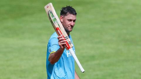 Warwickshire Bears all-rounder Beau Webster raises his bat to the crowd during the match with Northamptonshire