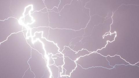 Bright lightning strike cuts through dark skies