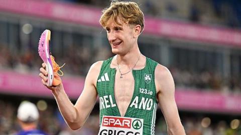 Nick Griggs holding the shoe that came off during Monday's 5000m final