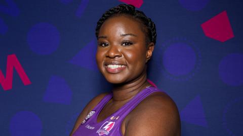 Dark-haired Sammy Wallace-Joseph smiling wearing a purple Loughborough Lightning vest. Her hair is tied back in a braid. 
