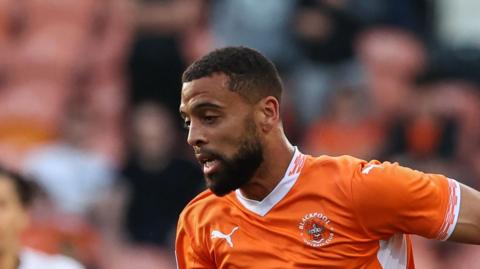 CJ Hamilton playing for Blackpool in their home kit 